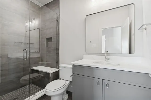 a bathroom with a sink toilet vanity and shower