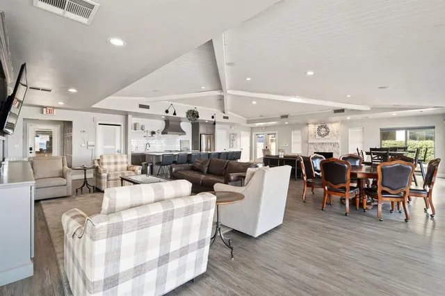 a living room with lots of white furniture and wooden floor