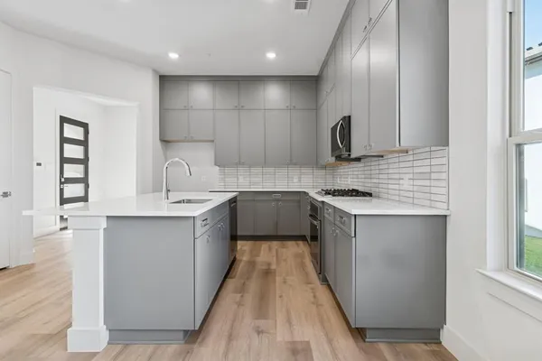 a kitchen with kitchen island granite countertop a sink stove and cabinets