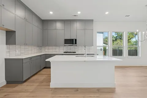 a kitchen with kitchen island a sink a stove a counter space and a window