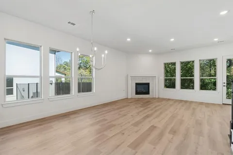 a view of an empty room with a window and fireplace