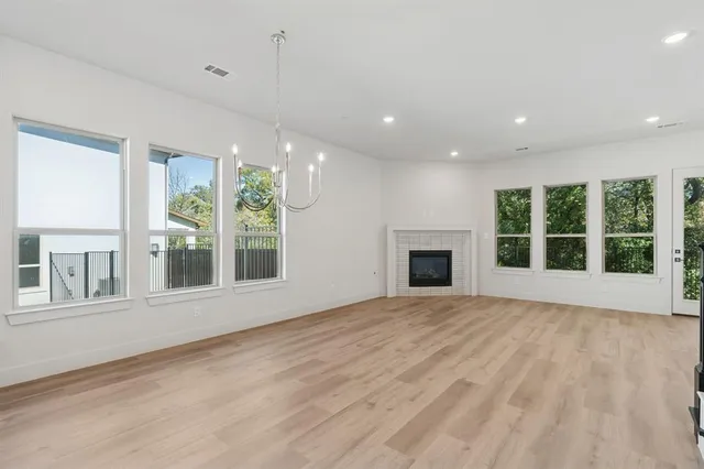 a view of an empty room with a window and fireplace