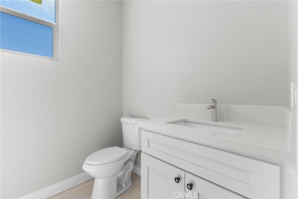 1341 East 8th Street Beaumont, CA 92223 - Photo 11 of 38 a bathroom with a granite countertop toilet and a sink