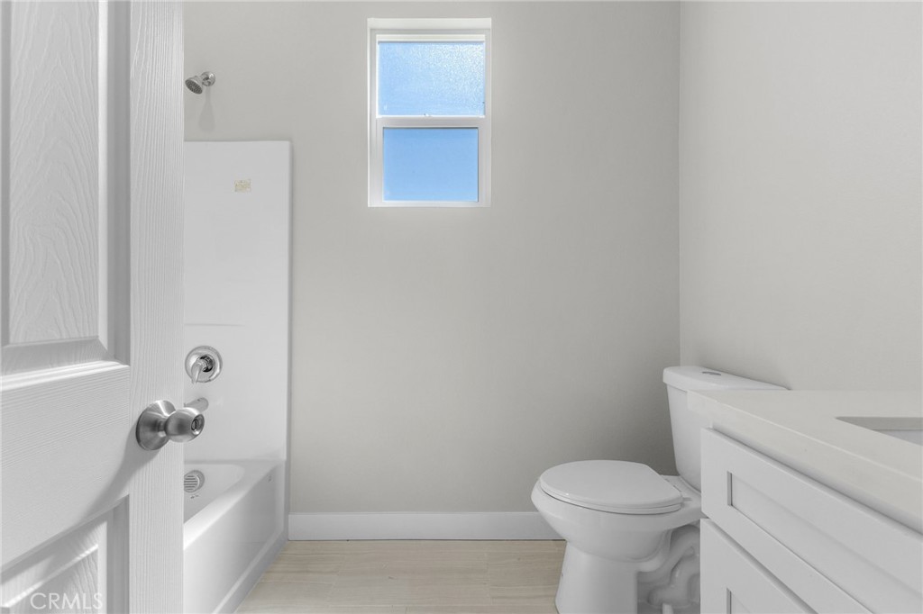 1341 East 8th Street Beaumont, CA 92223 - Photo 13 of 38 a white toilet sitting next to a bath tub