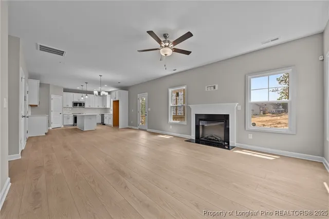 a view of an empty room with a fireplace and a window