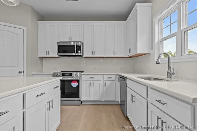 a kitchen with stainless steel appliances granite countertop white cabinets a sink and dishwasher