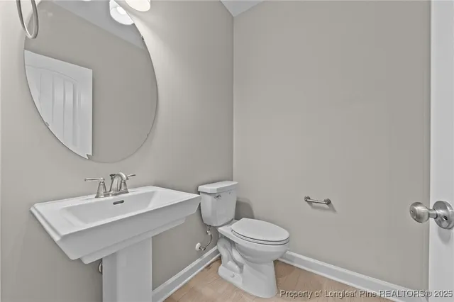 a bathroom with a toilet a sink and mirror