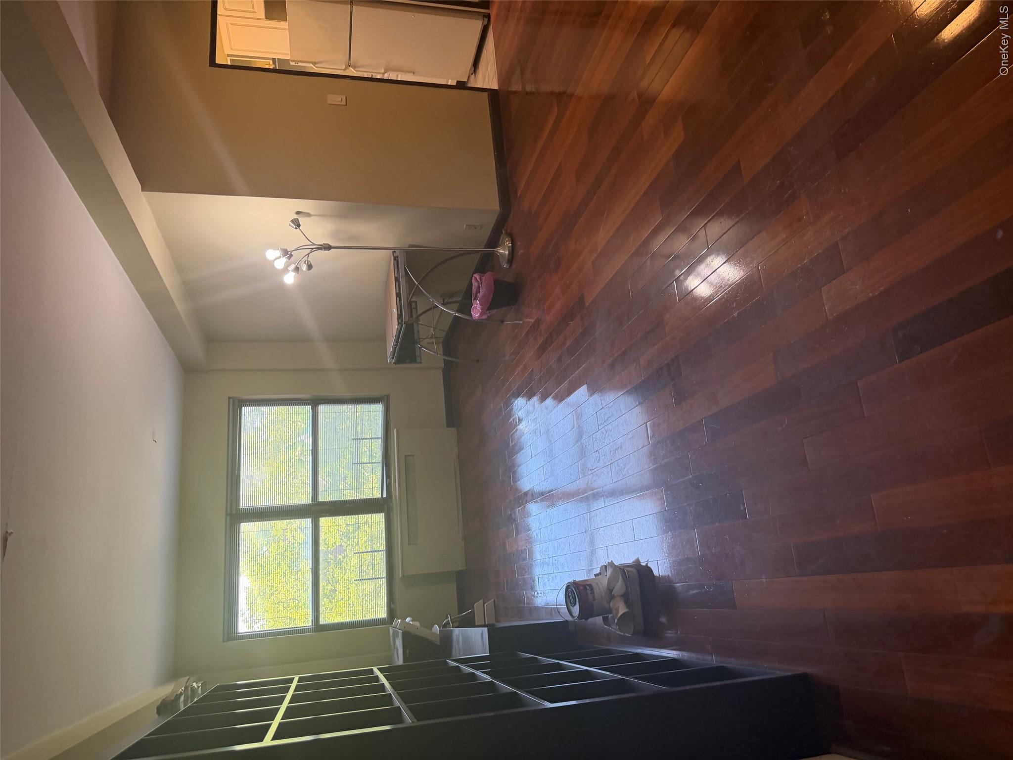 99-32 66th Road, Unit 3AA Queens, NY 11374 - Photo 2 of 9 an empty room with wooden floor and windows