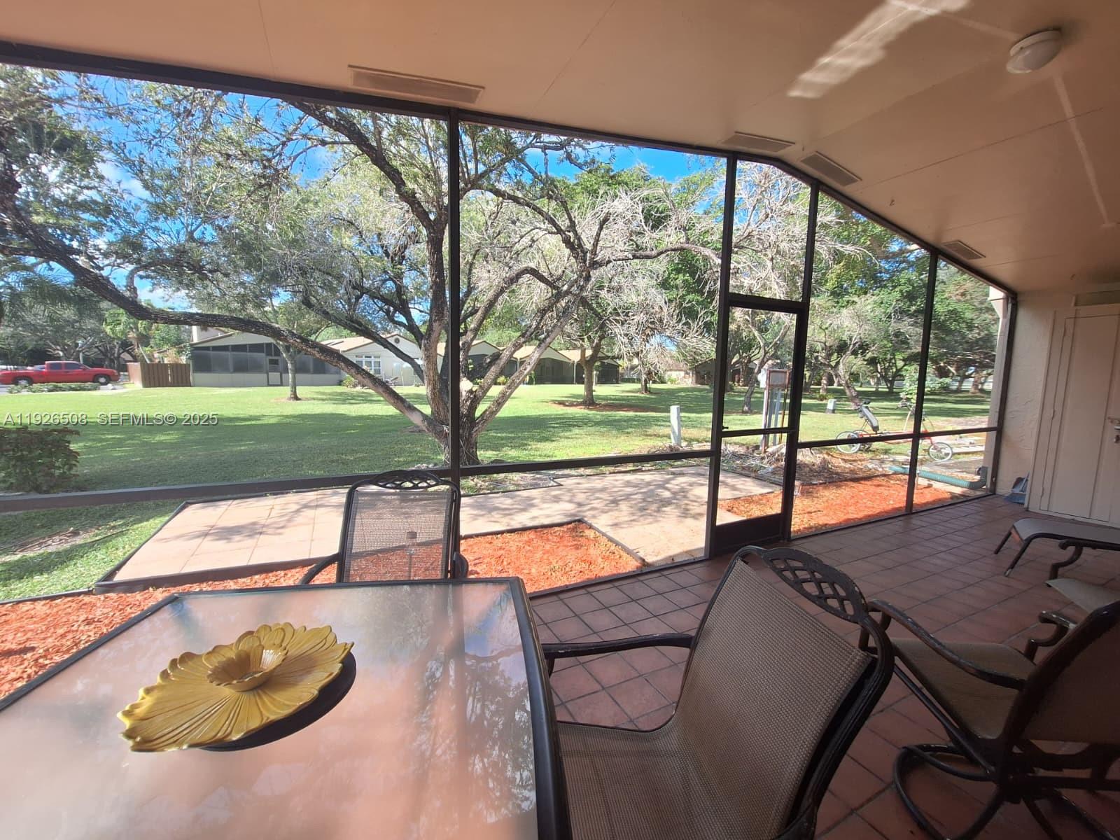 22295 Timberly Drive, Unit 22295 Boca Raton, FL 33428 - Photo 12 of 68 a view of a patio with a table chairs and a backyard