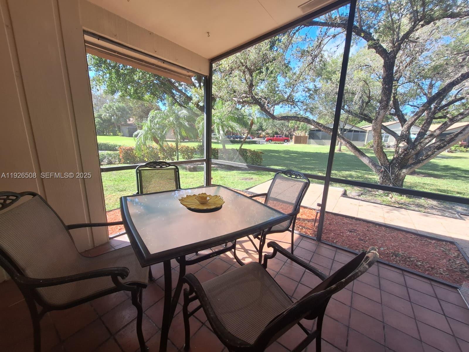 22295 Timberly Drive, Unit 22295 Boca Raton, FL 33428 - Photo 14 of 68 a view of a patio with a table chairs and a table