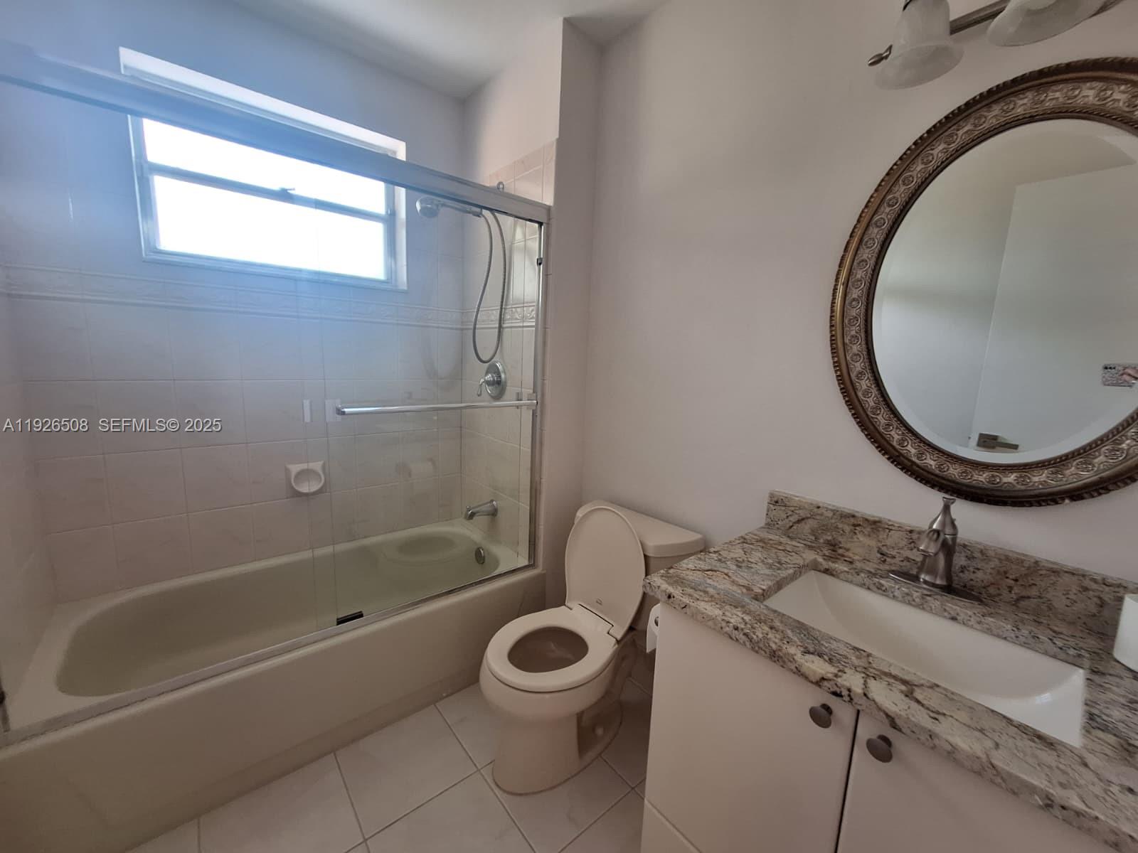 22295 Timberly Drive, Unit 22295 Boca Raton, FL 33428 - Photo 23 of 68 a bathroom with a granite countertop toilet a sink and a mirror