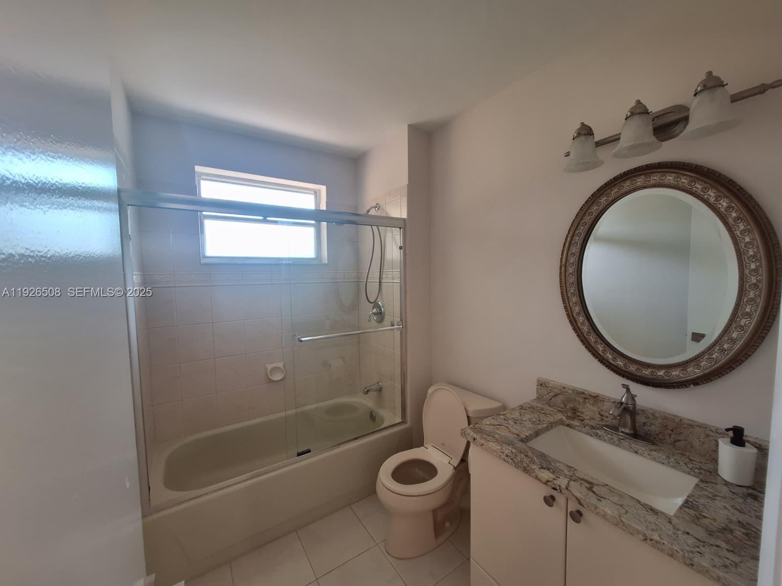22295 Timberly Drive, Unit 22295 Boca Raton, FL 33428 - Photo 24 of 68 a bathroom with a granite countertop toilet a sink and a mirror