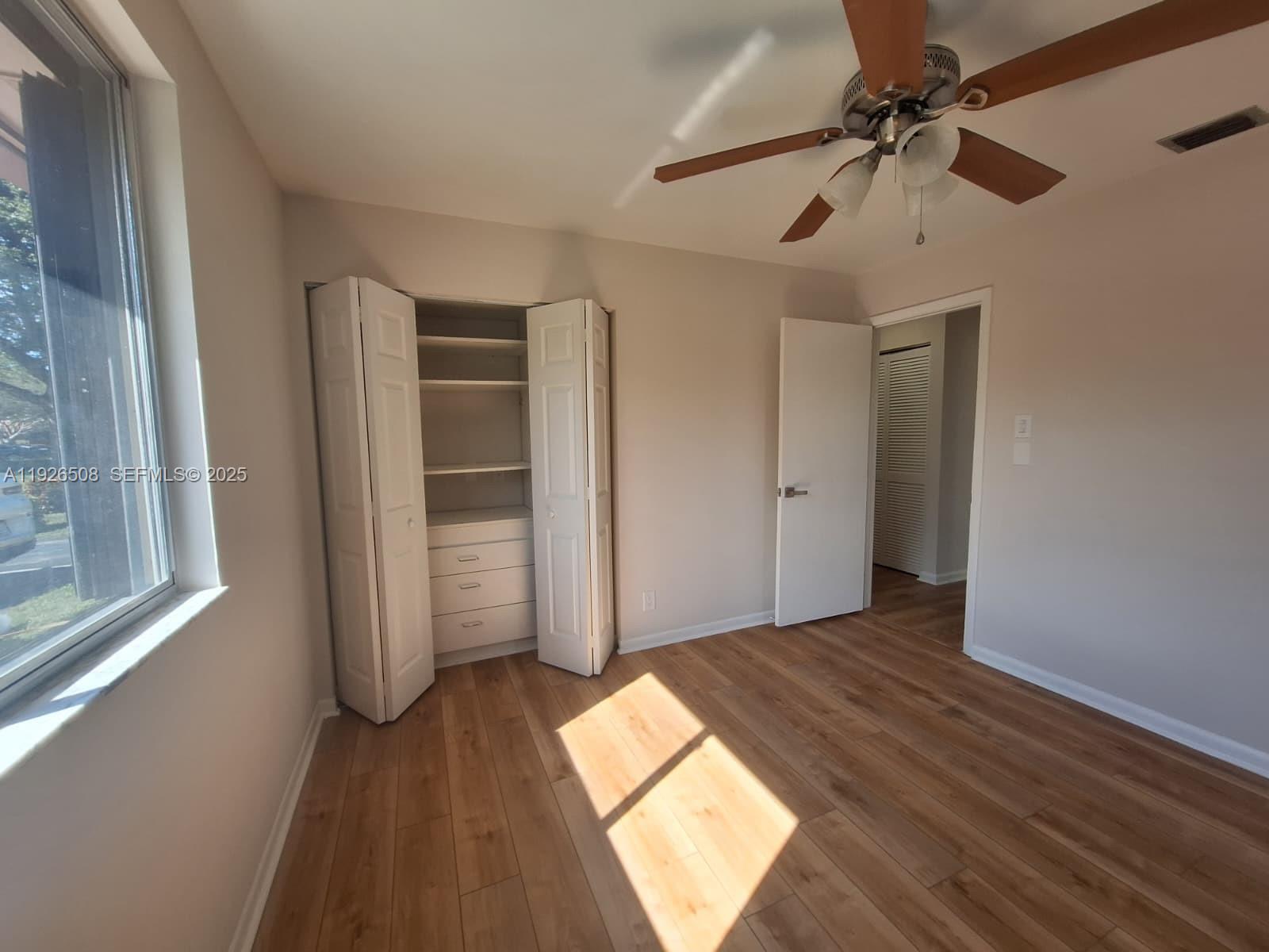 22295 Timberly Drive, Unit 22295 Boca Raton, FL 33428 - Photo 26 of 68 a view of empty room with wooden floor and fan