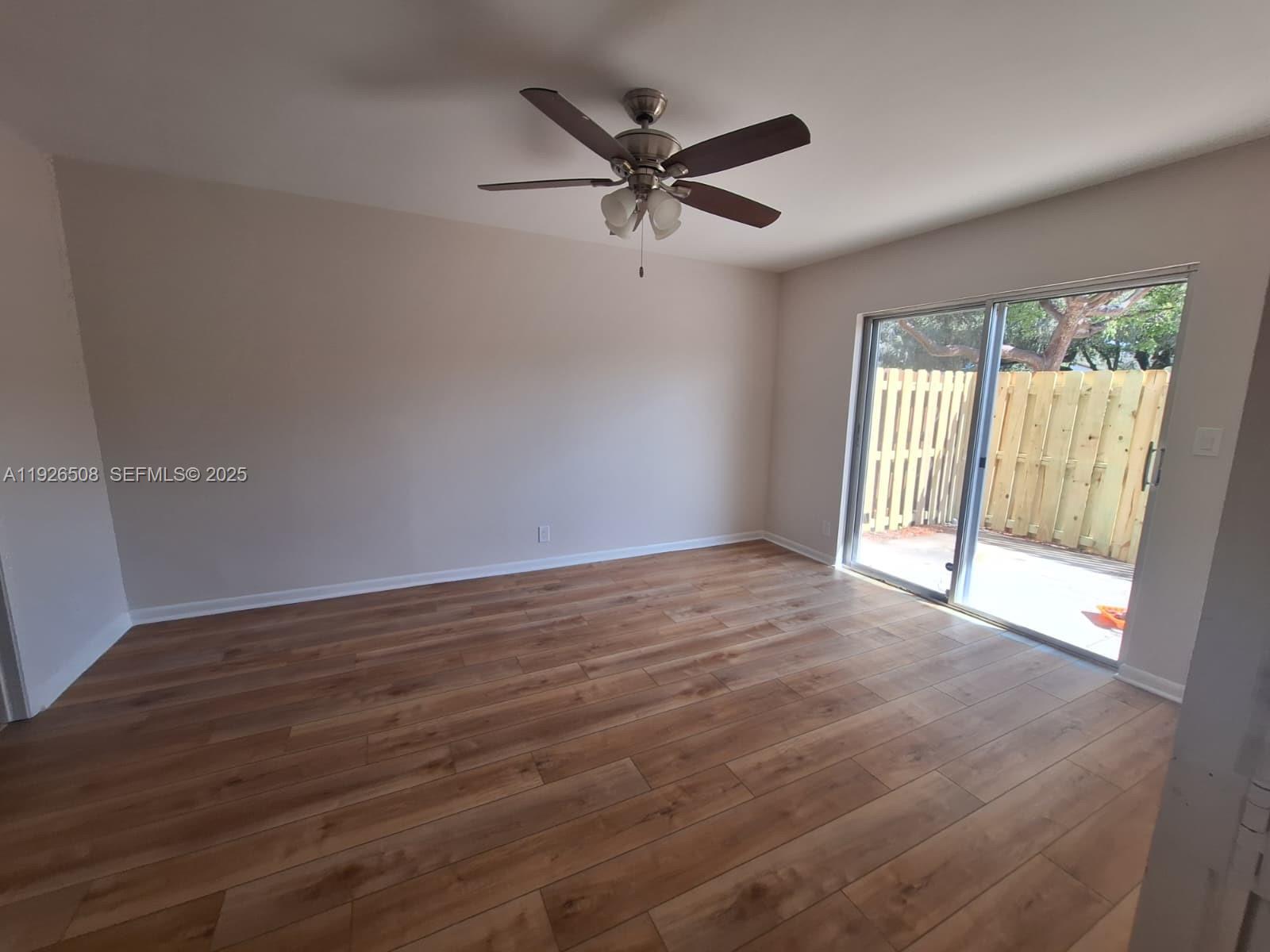 22295 Timberly Drive, Unit 22295 Boca Raton, FL 33428 - Photo 27 of 68 an empty room with wooden floor and windows