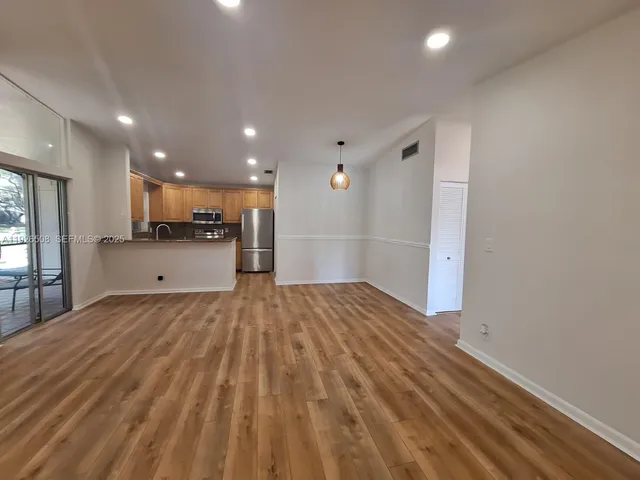 a view of a kitchen with a sink and a refrigerator