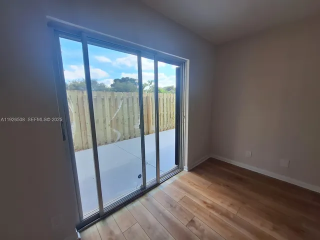 a view of a field with large trees