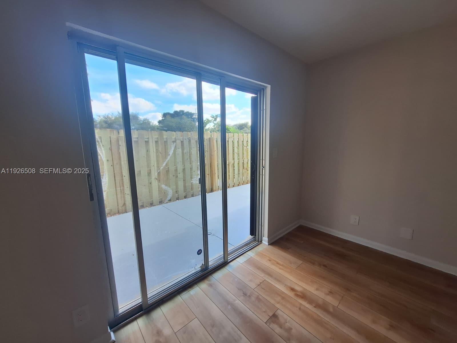 22295 Timberly Drive, Unit 22295 Boca Raton, FL 33428 - Photo 33 of 68 an empty room with wooden floor and windows