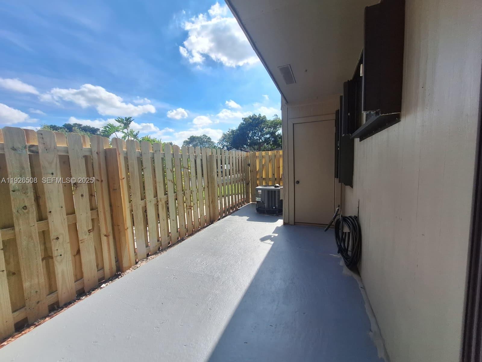 22295 Timberly Drive, Unit 22295 Boca Raton, FL 33428 - Photo 35 of 68 a view of a balcony with wooden floor and a bench