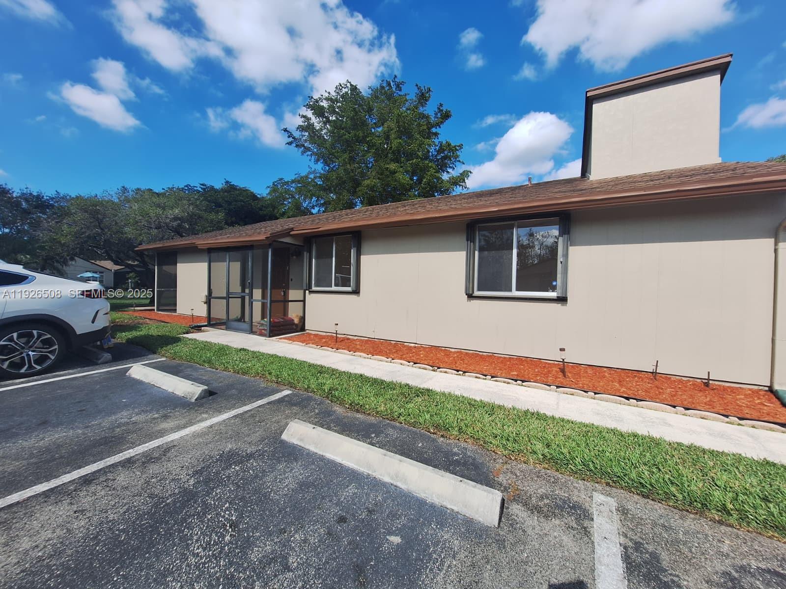 22295 Timberly Drive, Unit 22295 Boca Raton, FL 33428 - Photo 42 of 68 a front view of a house with a yard and garage