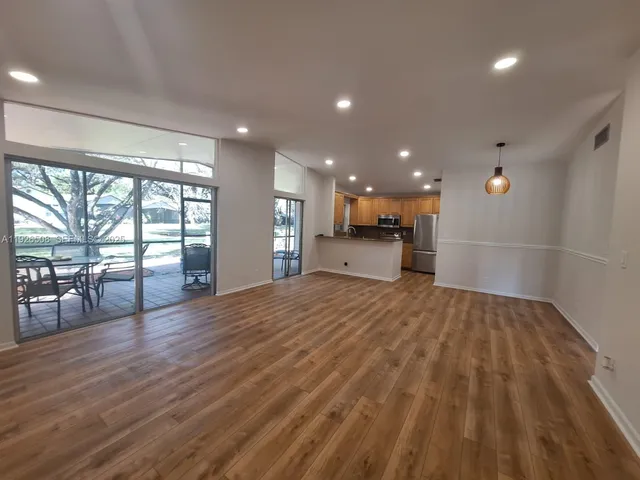 a view of empty room with wooden floor and windows