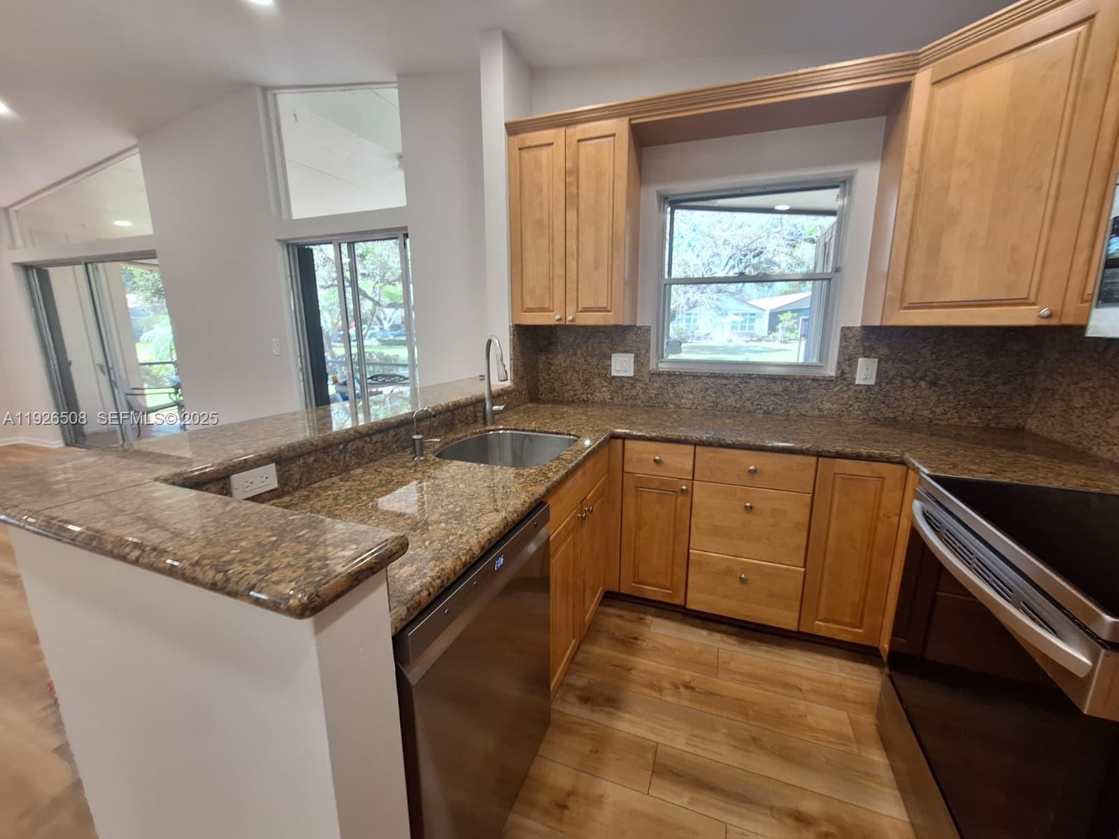 22295 Timberly Drive, Unit 22295 Boca Raton, FL 33428 - Photo 6 of 68 a kitchen with granite countertop a sink stove and cabinets