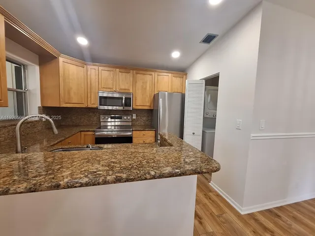 a kitchen with kitchen island granite countertop a sink stove and refrigerator