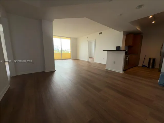 a view of a kitchen with wooden floor and a sink