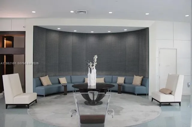 a living room with furniture a flat screen tv and kitchen view