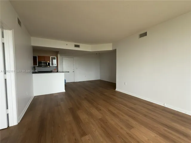a view of a kitchen with wooden floor and a sink