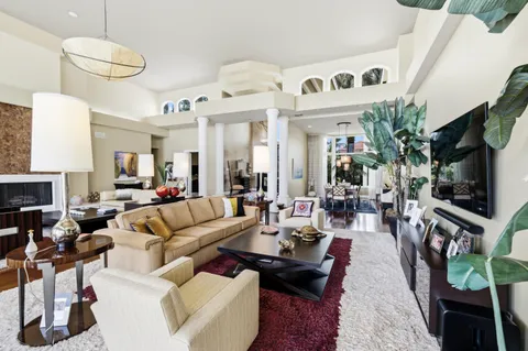 a living room with furniture a flat screen tv and kitchen view