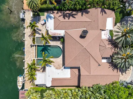 a front view of a house with swimming pool lawn chairs and a yard