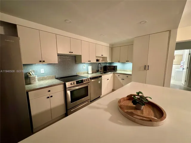 a kitchen with a sink stove and white cabinets