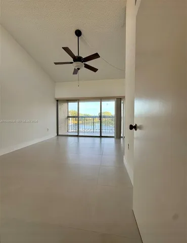 a view of a livingroom with a ceiling fan and window