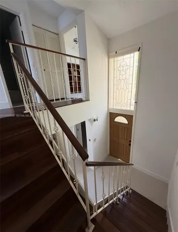 a view of staircase with railing and a window