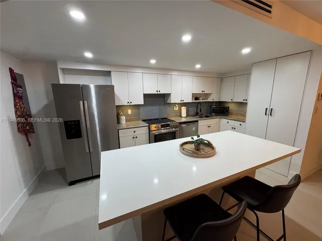 a kitchen with stainless steel appliances a refrigerator sink and microwave