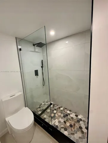 a bathroom with a granite countertop toilet a sink and a shower