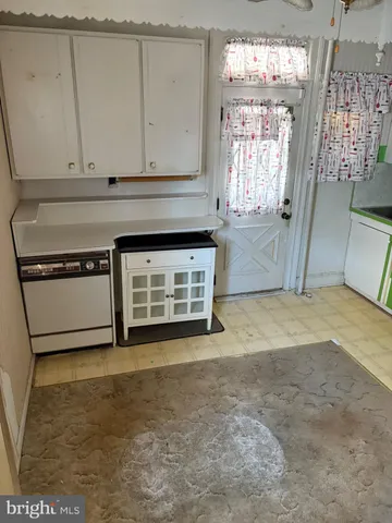 a view of a kitchen with fridge and window
