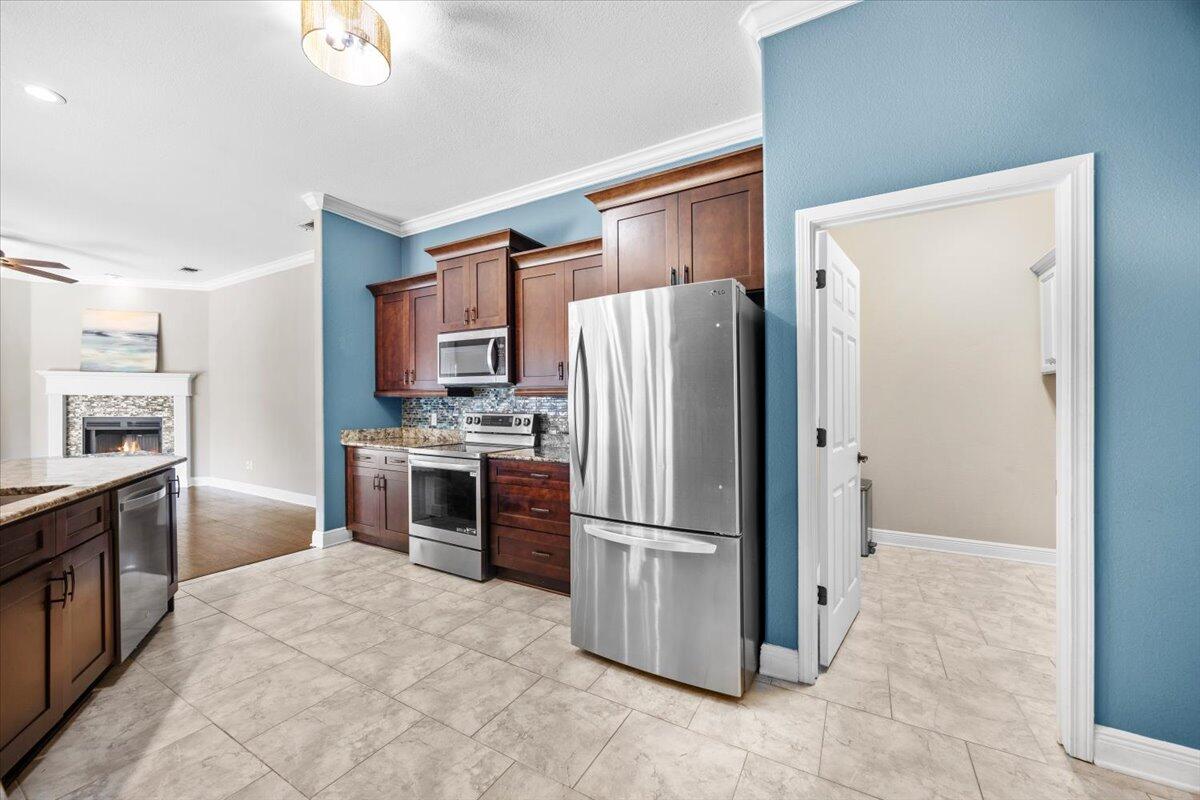 2691 Stormy Circle Navarre, FL 32566 - Photo 22 of 47 a kitchen with stainless steel appliances granite countertop a refrigerator and a stove top oven