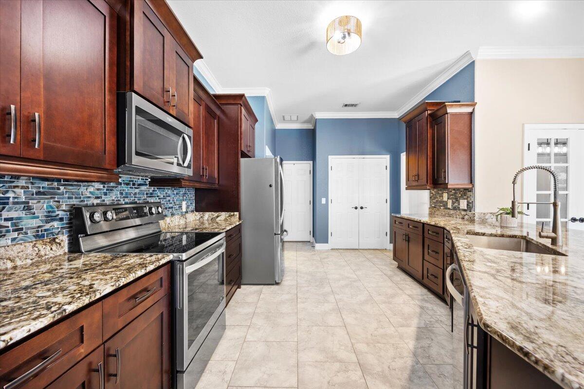 2691 Stormy Circle Navarre, FL 32566 - Photo 23 of 47 a kitchen with stainless steel appliances granite countertop a sink stove and refrigerator