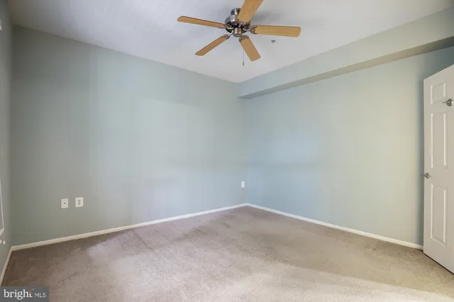 an empty room with chandelier fan