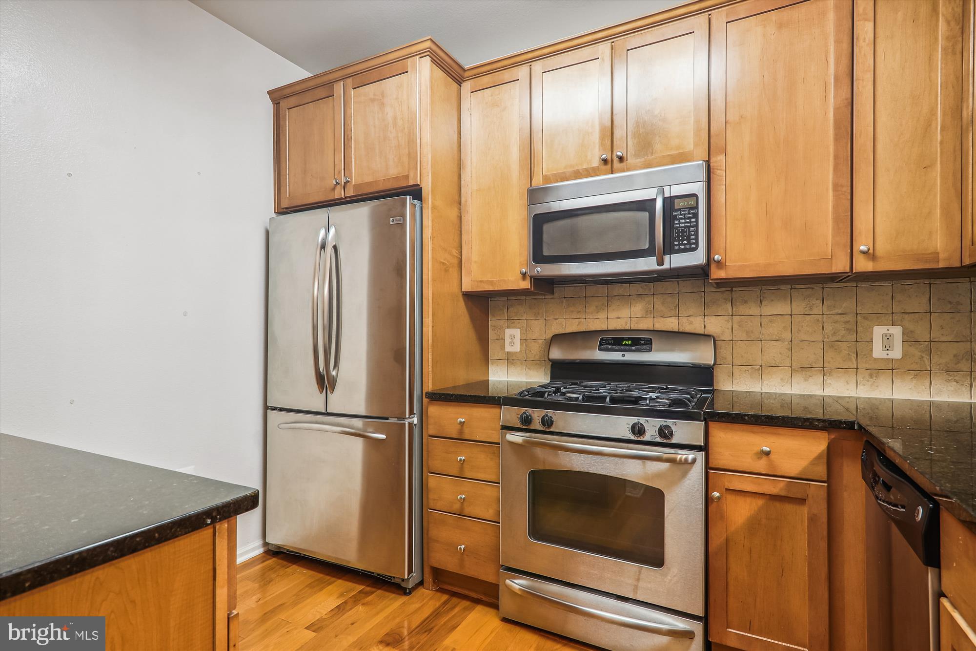 11800 Old Georgetown Road, Unit 1424 Rockville, MD 20852 - Photo 4 of 34 a kitchen with granite countertop wooden cabinets stainless steel appliances and a refrigerator