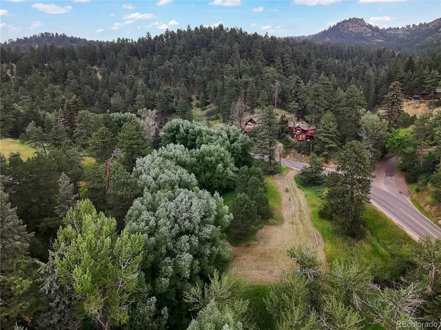 an aerial view of mountains residential house and green space