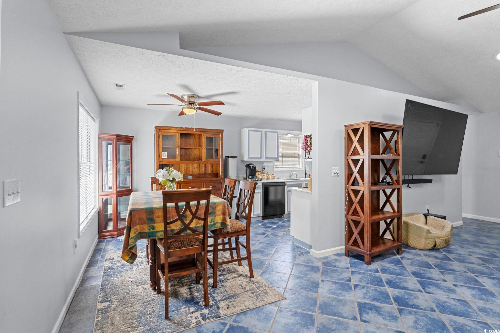 8069 Resin Road Murrells Inlet, SC 29576 - Photo 12 of 40 Dining room with ceiling fan, vaulted ceiling, and a textured ceiling