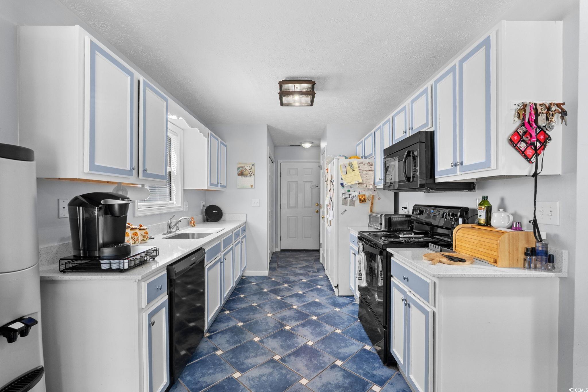 8069 Resin Road Murrells Inlet, SC 29576 - Photo 15 of 40 Kitchen with black appliances, a textured ceiling, blue cabinets, and light stone counters