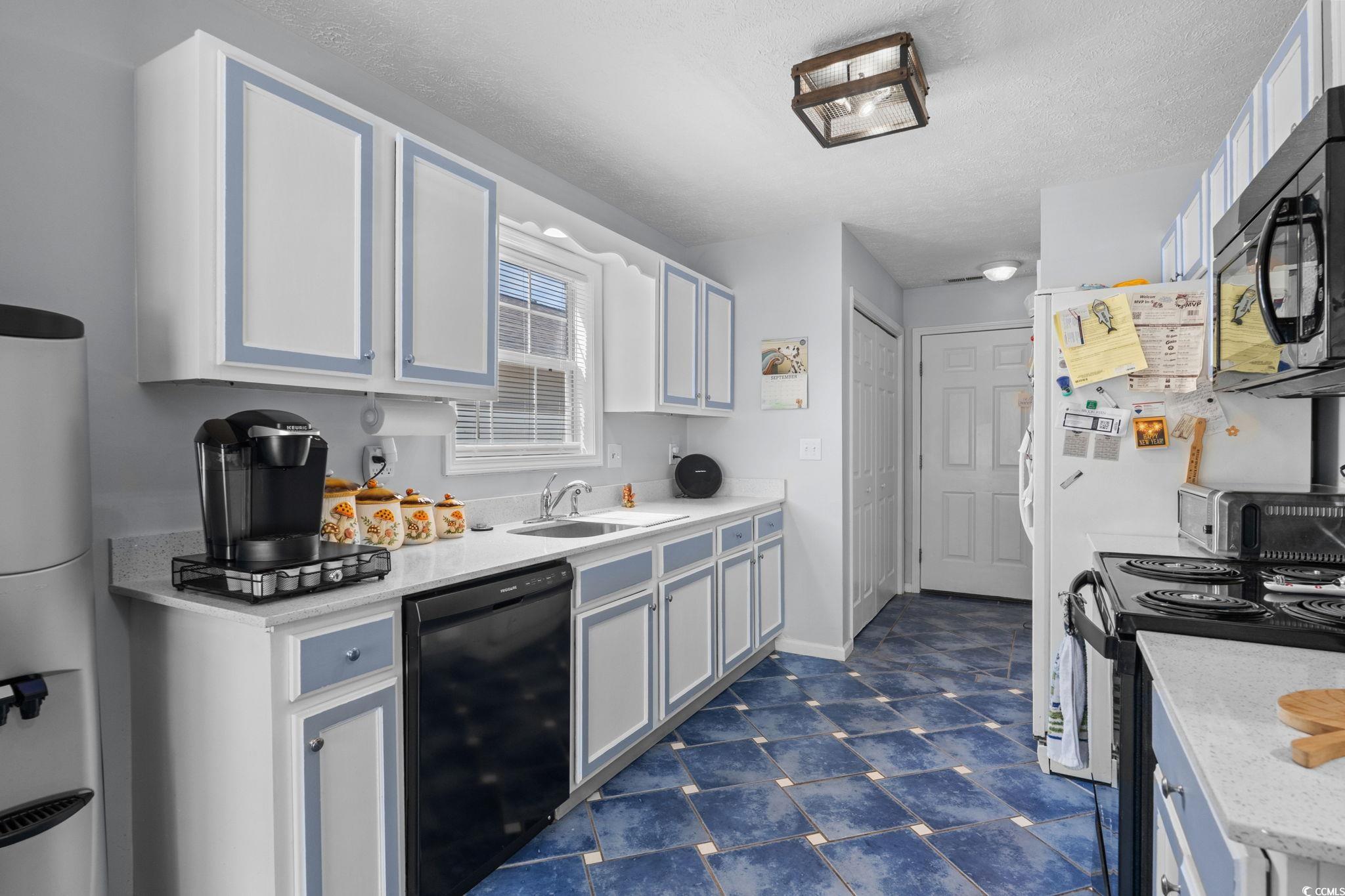 8069 Resin Road Murrells Inlet, SC 29576 - Photo 16 of 40 Kitchen featuring black appliances, a textured ceiling, and light stone countertops