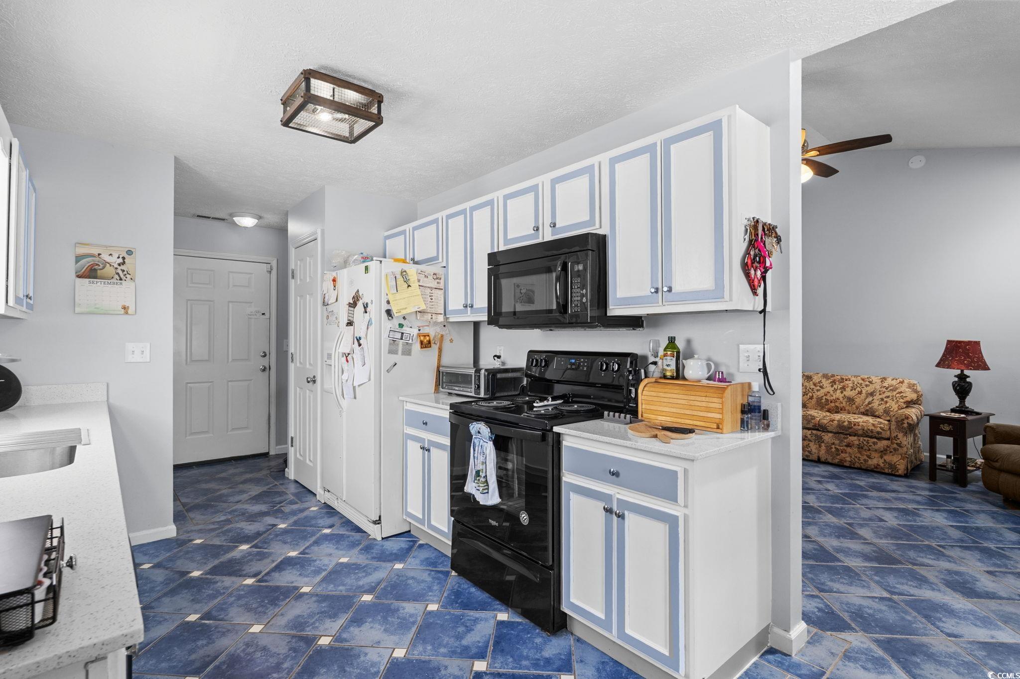 8069 Resin Road Murrells Inlet, SC 29576 - Photo 17 of 40 Kitchen featuring black appliances, ceiling fan, white cabinetry, and a textured ceiling