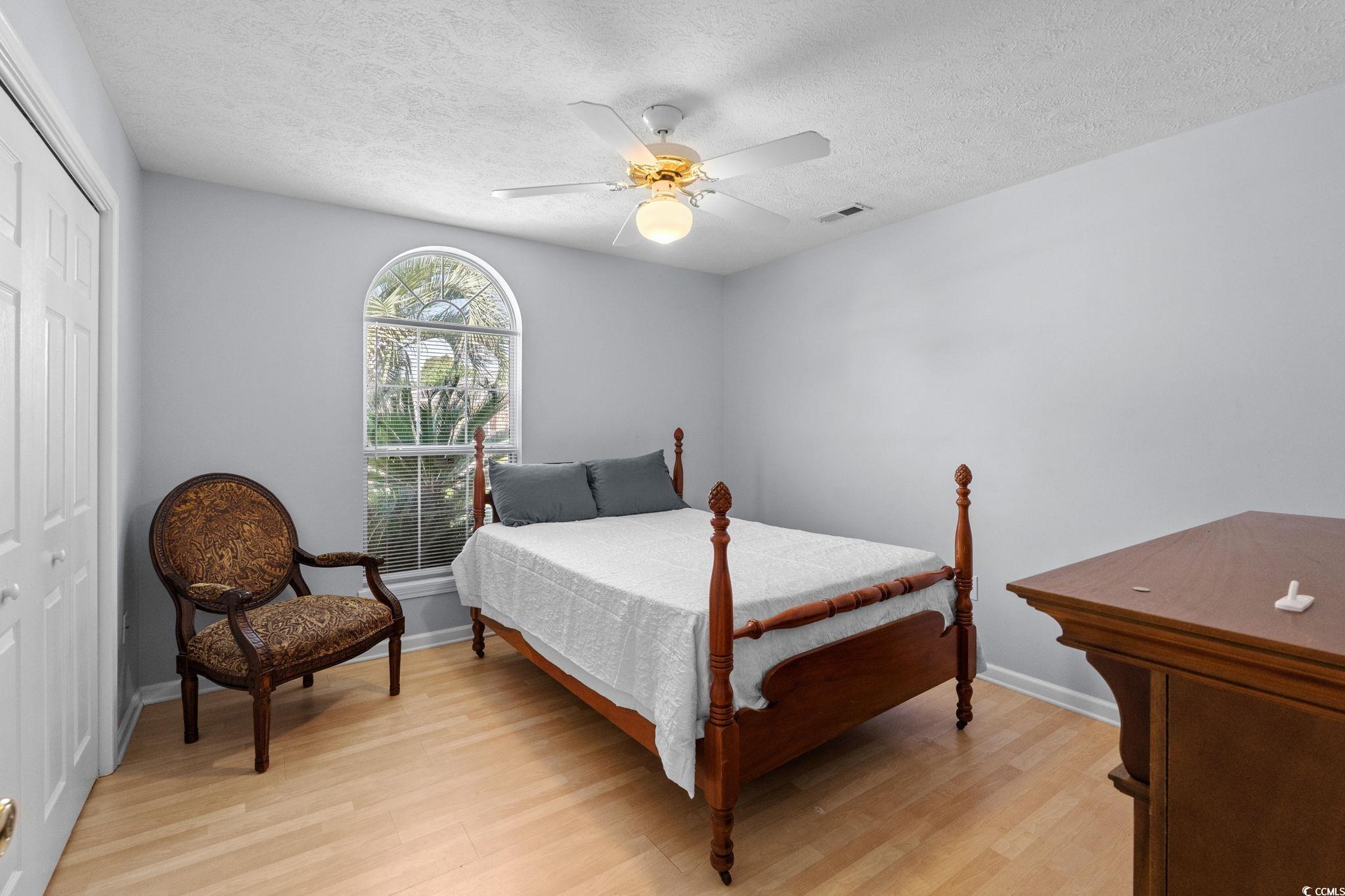 8069 Resin Road Murrells Inlet, SC 29576 - Photo 21 of 40 Bedroom with a closet, light wood finished floors, a textured ceiling, and a ceiling fan