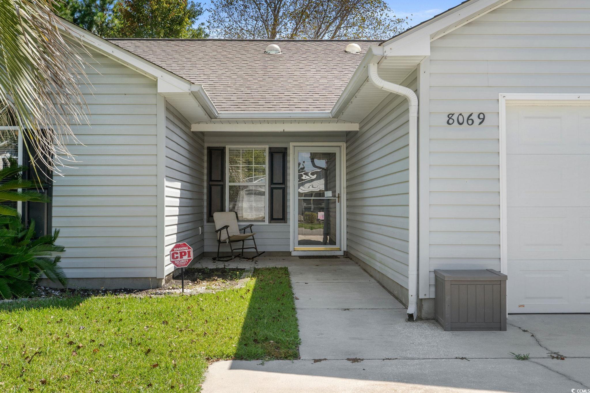 8069 Resin Road Murrells Inlet, SC 29576 - Photo 3 of 40 Entrance to property with a shingled roof, an attached garage, and a lawn