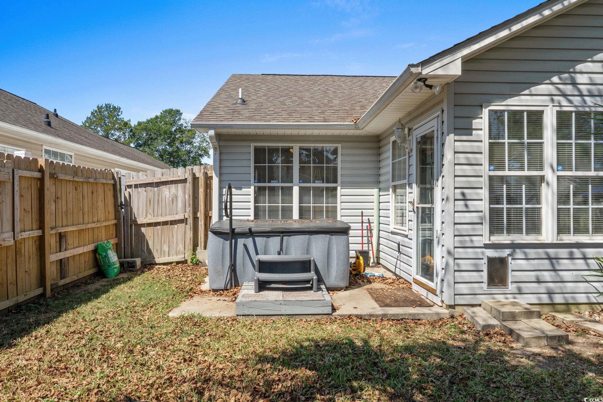 8069 Resin Road Murrells Inlet, SC 29576 - Photo 32 of 40 Back of property with a hot tub, a patio area, and roof with shingles