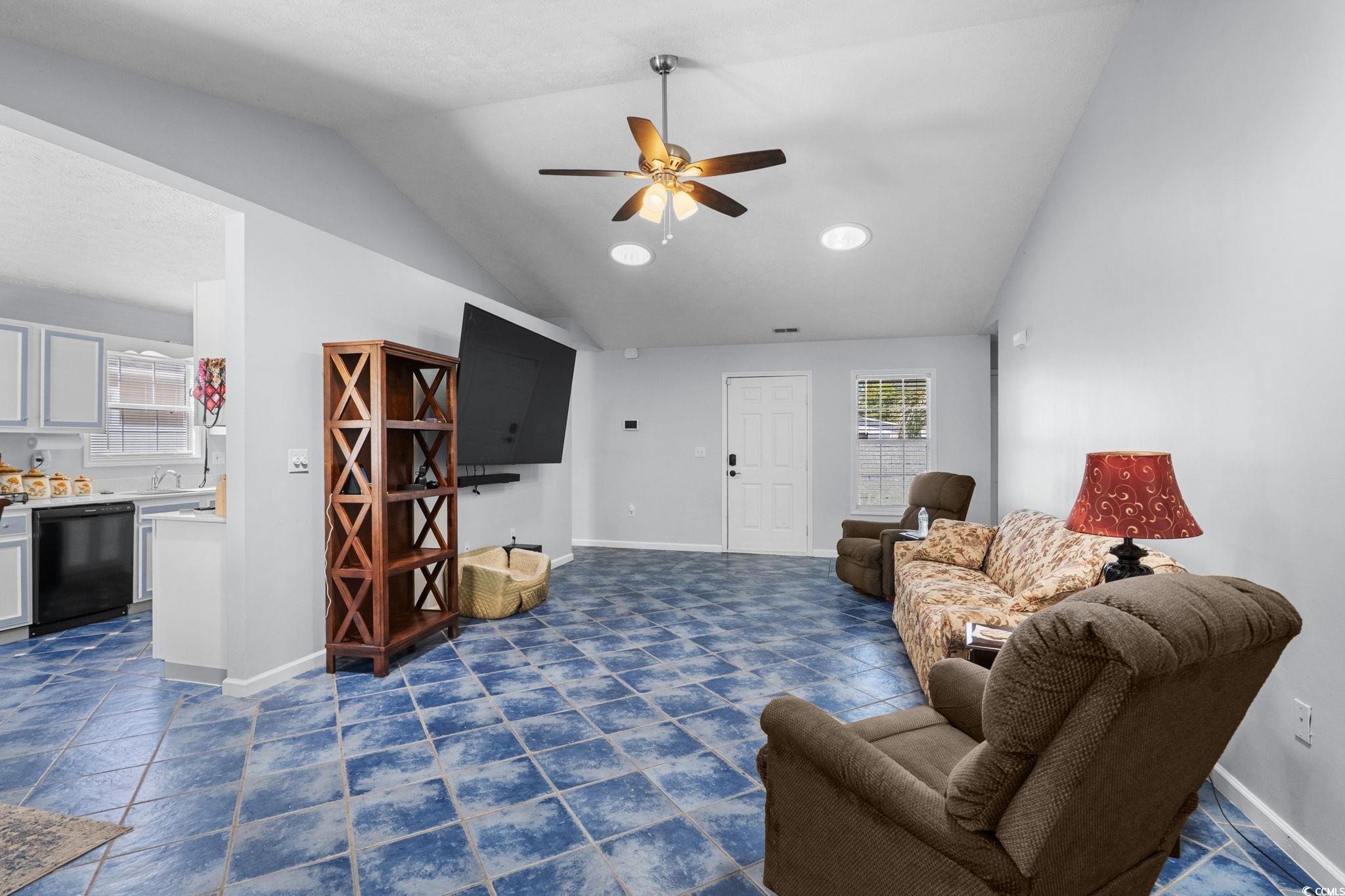 8069 Resin Road Murrells Inlet, SC 29576 - Photo 9 of 40 Living room featuring lofted ceiling, ceiling fan, and dark tile patterned flooring